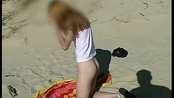 teen plays with dildo on the beach