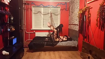 The slave is tied in an uncomfortable position with ropes, his legs are spread and hang so that Dominatrix Nikа can easily fuck his ass. Femdom, rope bondage, pegging.